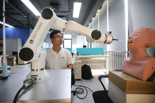  珠海澳科大科技研究院工作人员正在研究用于自动核酸采样的机器人。