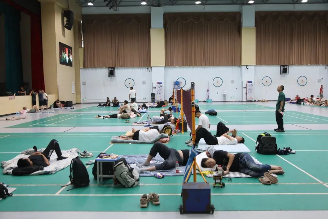 7月20日,在横琴一中庇护所内(文体中心),饼干,矿泉水,八宝粥等物资整齐堆放在角落里,每位受庇护群众的身边都分发有矿泉水、饼干、火腿肠等食品。 曾遥 摄.jpg